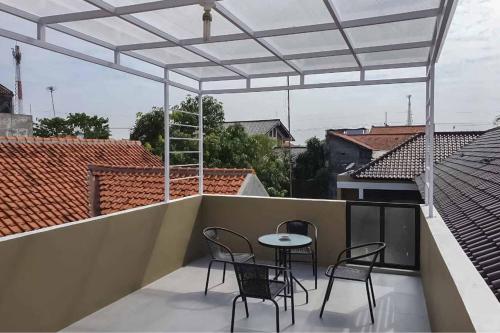 a patio with chairs and a table on a balcony at Jatiwangi Syariah Guest House Mitra RedDoorz in Majalengka