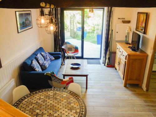 a living room with a couch and a table at Maison de la Ferme in Lézardrieux