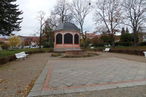 a gazebo in a park with two benches at Apartment Am Kurpark in Bad Frankenhausen