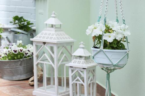 two white lanterns on a table with a potted plant at B&B Ulivo Gaio in San Miniato