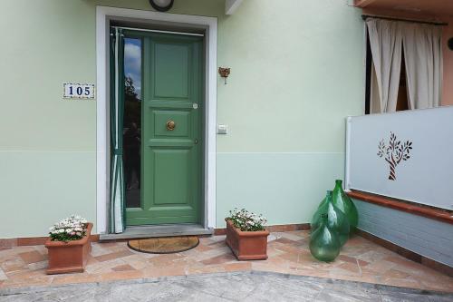 a green door on the side of a house with plants at B&B Ulivo Gaio in San Miniato