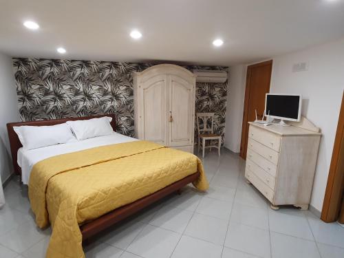 - une chambre avec un lit, une commode et une télévision dans l'établissement Lady Room, à Turi