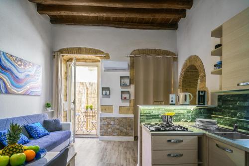 een keuken en een woonkamer met een blauwe bank bij The Good Place in Cagliari