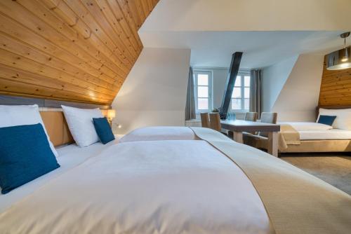 a hotel room with a large bed and a desk at Hotel Am Fischmarkt in Stade
