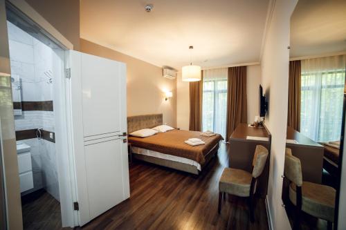 a hotel room with a bed and a bathroom at Кайзервальд Клуб in Karpaty