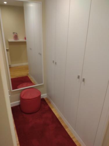 Zimmer mit einem roten Stuhl und einem Spiegel in der Unterkunft Furadouro Beach Spot in Ovar