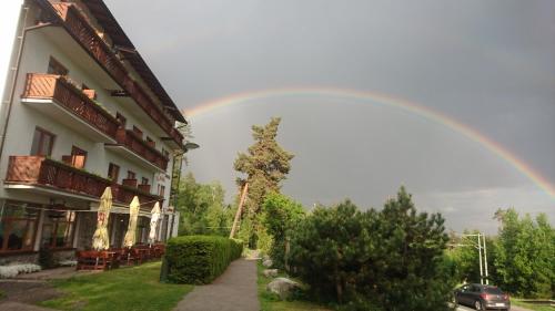 a rainbow in the sky above a building at Erika penzión in Vysoke Tatry - Tatranska Lesna