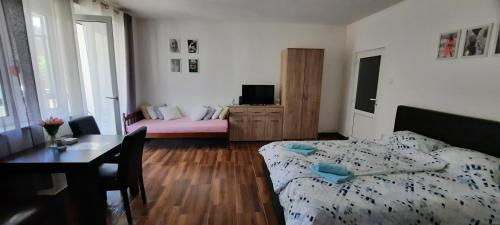 a bedroom with a bed and a table with a tableablish at Stan na dan DUNJA 2 in Vršac