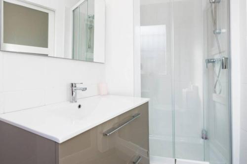une salle de bain blanche avec un lavabo et une douche dans l'établissement Primavera, à Avignon