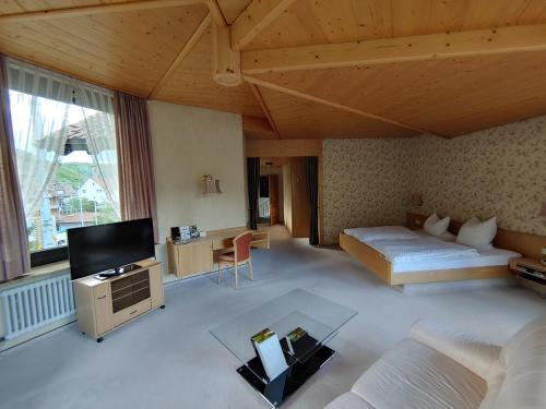 a large room with a bed and a tv at Hotel Adler in Lichtenstein/ Baden Wurttemberg
