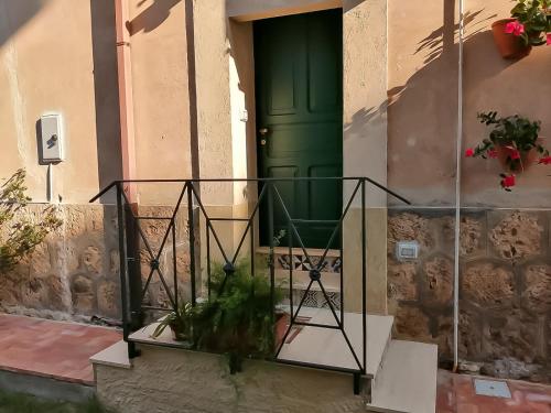 a green door on a building with a plant at Annina Home in Paestum