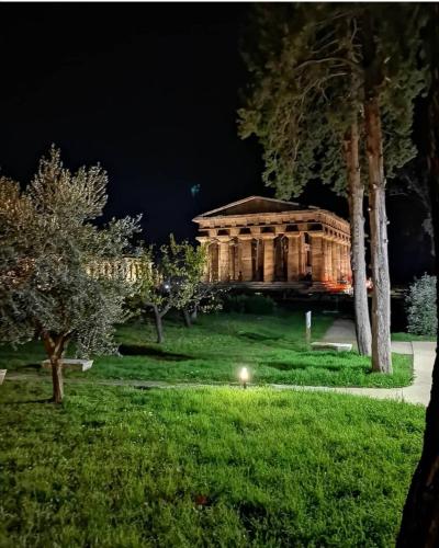 a building in the middle of a park at night at Annina Home in Paestum