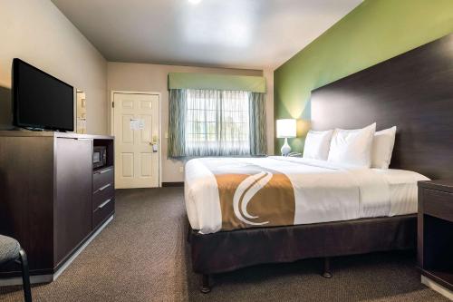 a bedroom with a large bed and a flat screen tv at Quality Inn & Suites Bainbridge Island in Winslow