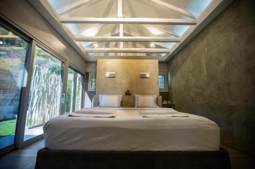 a bedroom with a large bed in front of a window at Spa Villa Skaloma in Nafpaktos