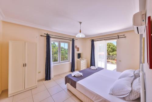 a bedroom with a large bed and a window at Villa Günbatımı in Kaş