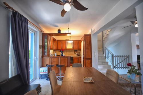 a dining room with a table and a kitchen at Maisonette Ilios in Plisioí