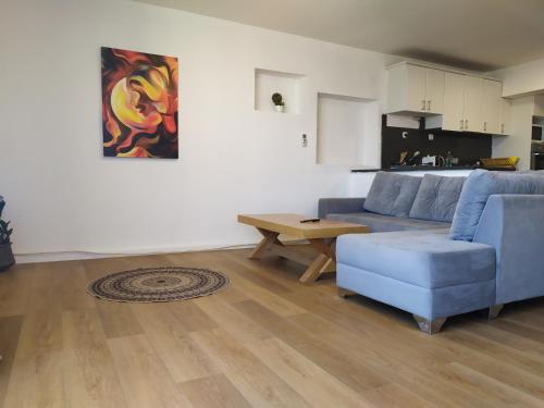 uma sala de estar com um sofá azul e uma mesa em Dekel-City center and Sea view -new listing em Eilat