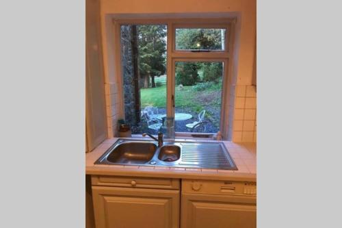 a kitchen with a sink and a window at Historic 17th century farmhouse in Wales in Gwernymynydd