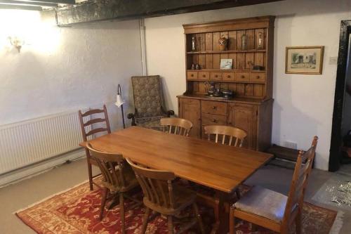a dining room with a wooden table and chairs at Historic 17th century farmhouse in Wales in Gwernymynydd