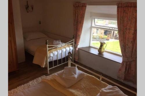 a bedroom with a crib and a window at Historic 17th century farmhouse in Wales in Gwernymynydd