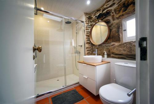 uma casa de banho com um chuveiro, um WC e um lavatório. em Casas da Loureira - Casa do Pote em Vila Nova de Cerveira