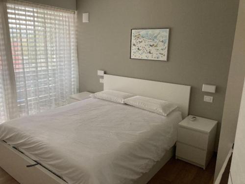 a bedroom with a white bed and a window at Villa Greta in Laives