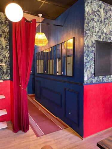 a room with a blue door and red curtains at Coco Marco Hôtel in Nyons