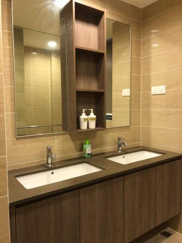 a bathroom with two sinks and a large mirror at By the sea Duplex penthouse baby in Batu Ferringhi