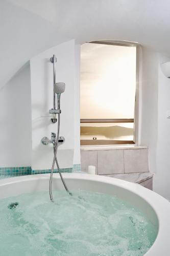 a bath tub filled with water in a bathroom at Merovigliosso in Imerovigli