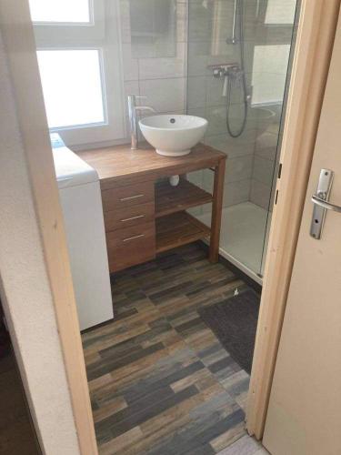 une salle de bain avec un lavabo et une douche dans l'établissement Maison avec jardinet, piscine commune à Lacanau océan, à Lacanau-Océan