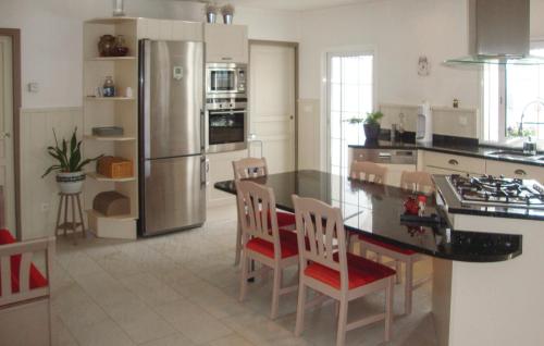 Il comprend une cuisine équipée d'un réfrigérateur, d'une table et de chaises. dans l'établissement Amazing Home In Arnaud-Guilhem, à Arnaud-Guilhem