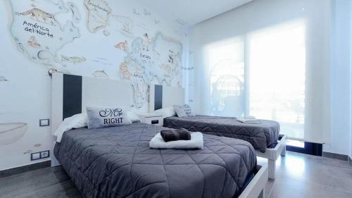1 Schlafzimmer mit 2 Betten und einer großen Wand in der Unterkunft INFINITY VIEW Arenales in Arenales del Sol