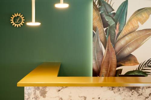 a yellow bench in a room with a green wall at Hotel Luxembourg in Thessaloniki