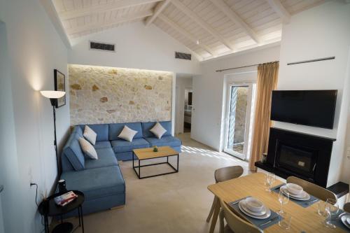 a living room with a blue couch and a table at Astrali Stone Villas in Paramythia