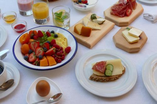 a table with plates of food and a bowl of fruit at Gasthof Weisses Kreuz in Naturno