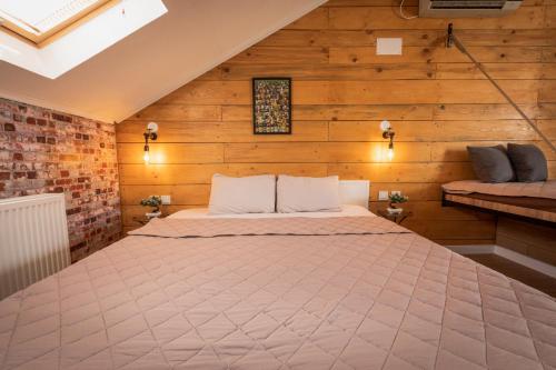 a large bed in a room with wooden walls at G apartments in Gevgelija