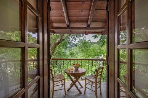 a room with a table and chairs on a balcony at Palios Stathmos in Miléai
