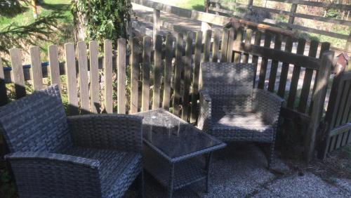 two chairs and a table in front of a fence at Idyllische kleine Ferienwohnung in Obdach