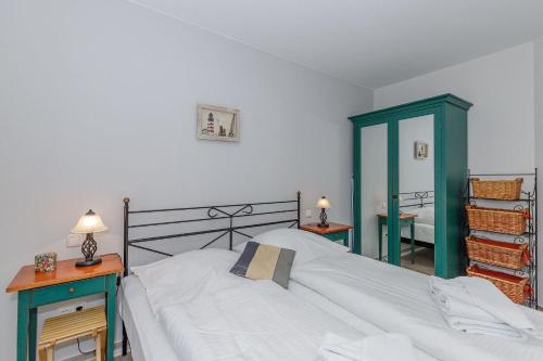 キュールングスボルンにあるStrandstrasse-16-Wohnung-23-App-Molli-377のベッドルーム1室(ベッド1台、テーブル2台、鏡付)