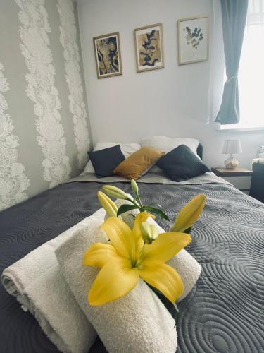 a yellow flower sitting on top of a bed at Apartamenty Majka in Zator