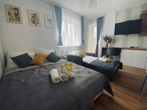 a bedroom with a bed with towels on it at Apartamenty Majka in Zator