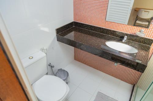 a bathroom with a toilet and a sink at Pousada Brisa do Forte in Cabo Frio