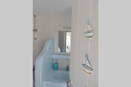 a bathroom with a sink and a sailboat on a shelf at Elena Studio in Logothetiánika