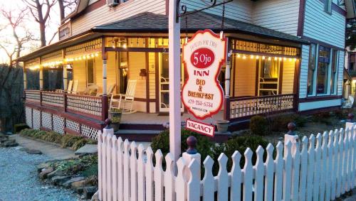 a white picket fence in front of a house at 5 Ojo Inn Bed and Breakfast in Eureka Springs