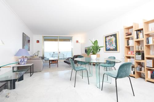 een woonkamer met een glazen tafel en stoelen bij Palm Beach Amazing view in Cannes
