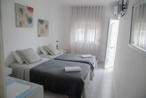 a bedroom with two beds and a window at Alojamento das Fontes in Alenquer