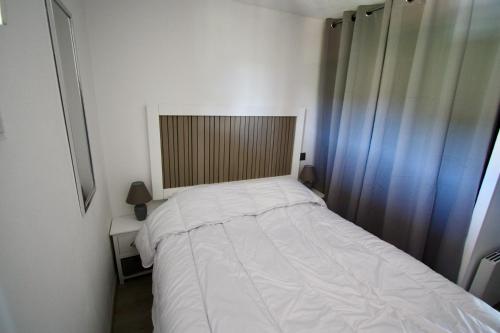 Un pequeño dormitorio con una cama blanca y una ventana en Entre mer et massif forestier de l'Estérel en Théoule-sur-Mer