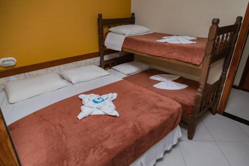 a room with two bunk beds with towels on them at Pousada Brisa do Forte in Cabo Frio