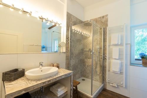 a white bathroom with a sink and a shower at Seehotel Lindenhof in Lychen