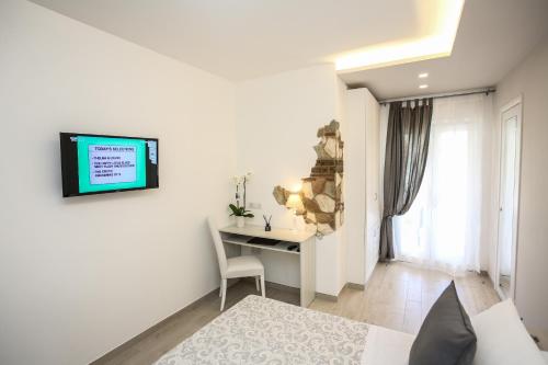 a white room with a desk and a tv on a wall at Relais Villa Anna in Anacapri